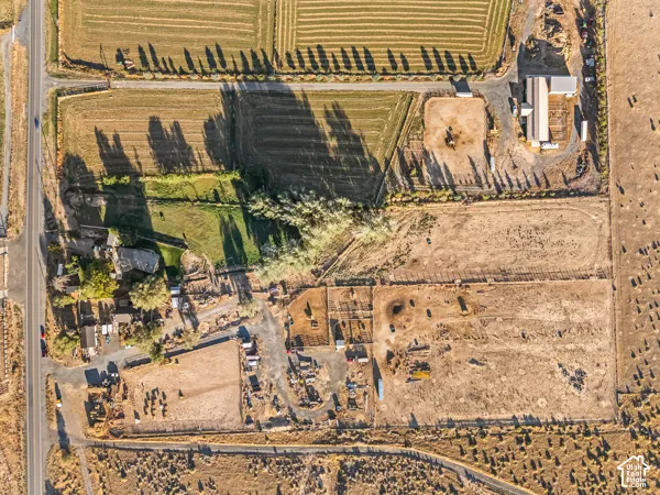 Aerial view of property and surrounding area featuring rural landscape and rows of crops