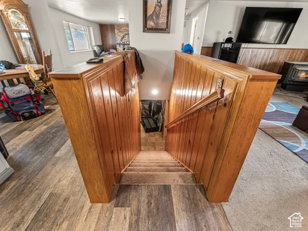 Stairway with a wood stove and wood finished floors