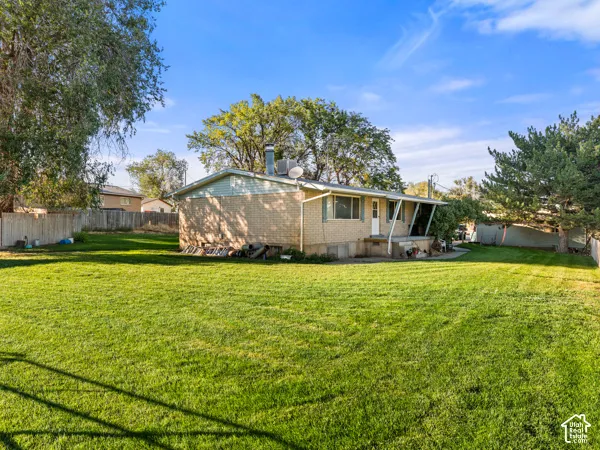 Back of property with a chimney and brick siding
