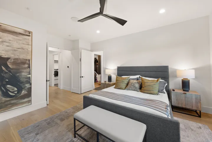 Bedroom with light wood-type flooring, recessed lighting, a ceiling fan, and washer / dryer