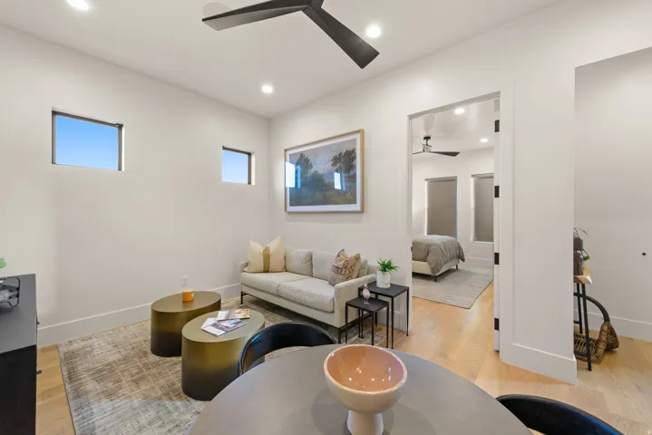 Living area featuring light wood-type flooring, a ceiling fan, and recessed lighting