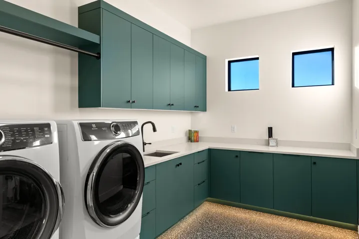 Laundry area with cabinet space, washer and dryer, and light aggregate flooring
