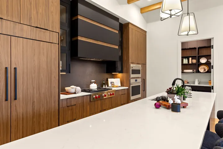 Kitchen featuring light stone counters, modern cabinets, and wood finish cabinetry