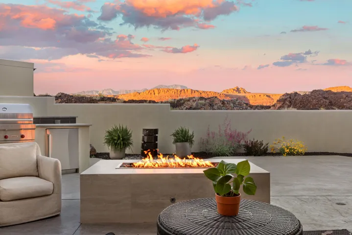 Patio terrace at dusk with a mountain view, a fire pit, an outdoor kitchen, and a patio