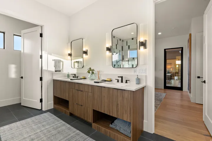 Full bathroom featuring double vanity and a shower stall
