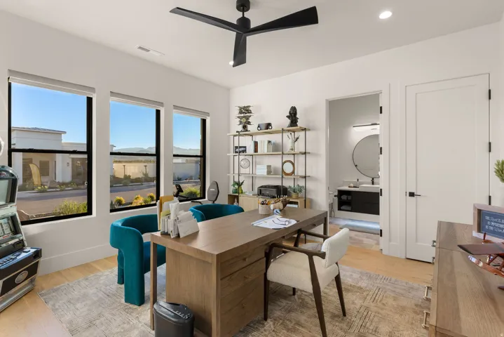 Office area with light wood-style flooring, ceiling fan, and recessed lighting