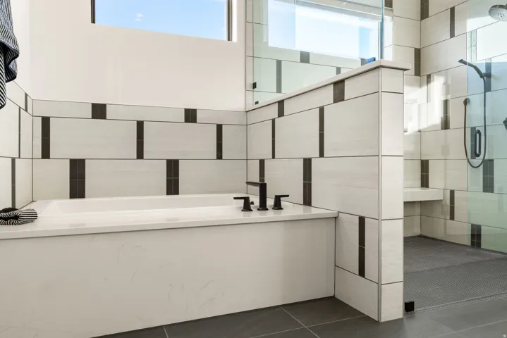 Bathroom with a bath, a stall shower, plenty of natural light, and dark tile patterned flooring