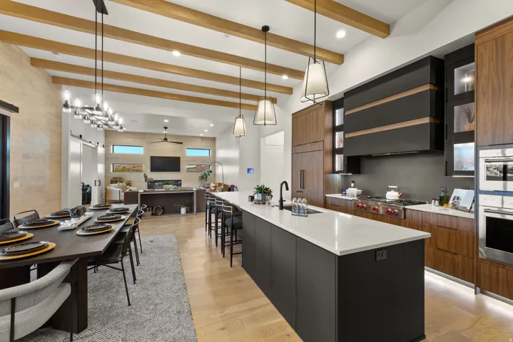 Kitchen featuring modern cabinets, pendant lighting, a large island, two tone cabinetry, and open floor plan