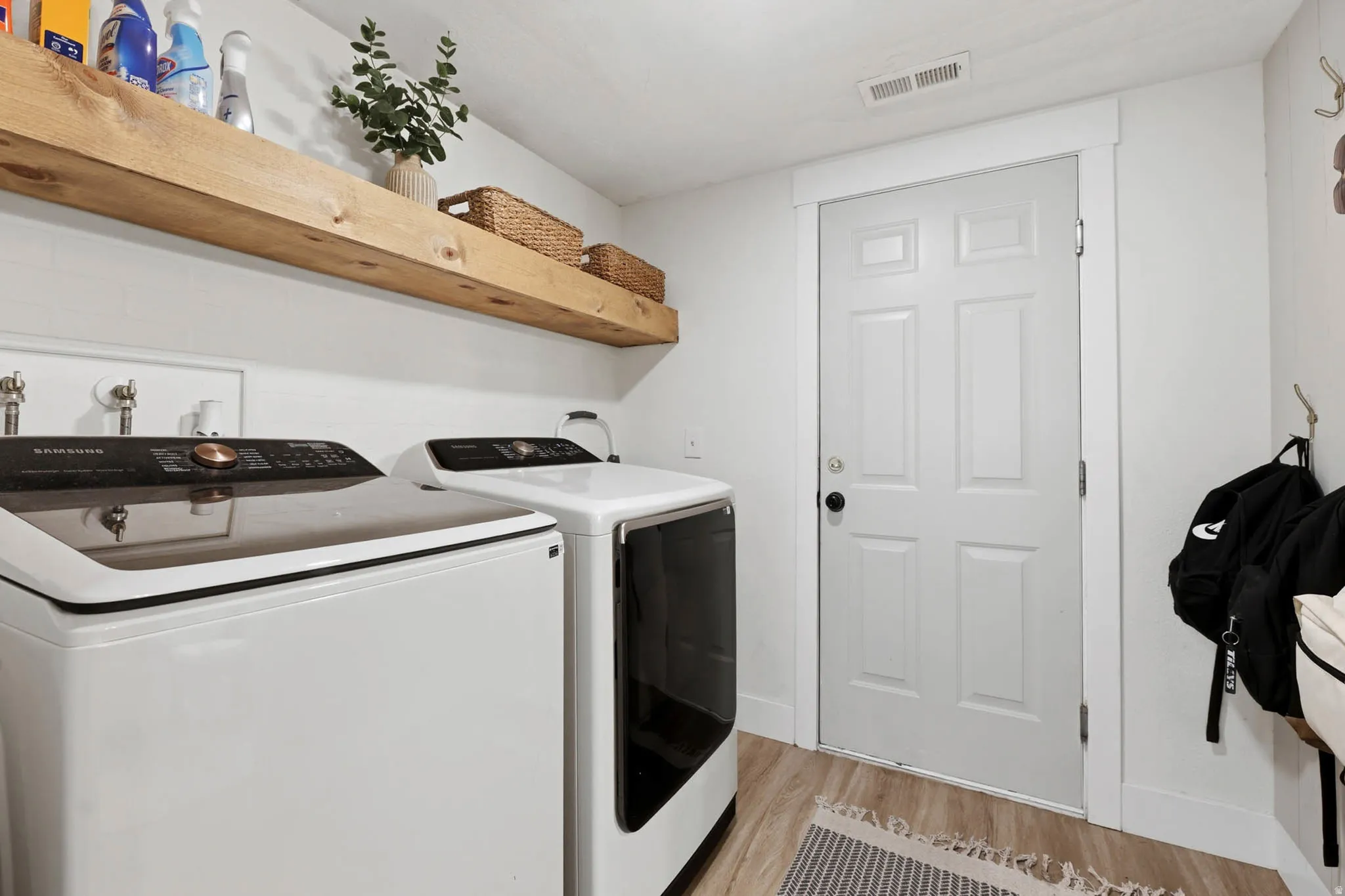 Laundry room featuring light wood-type flooring and washer and dryer