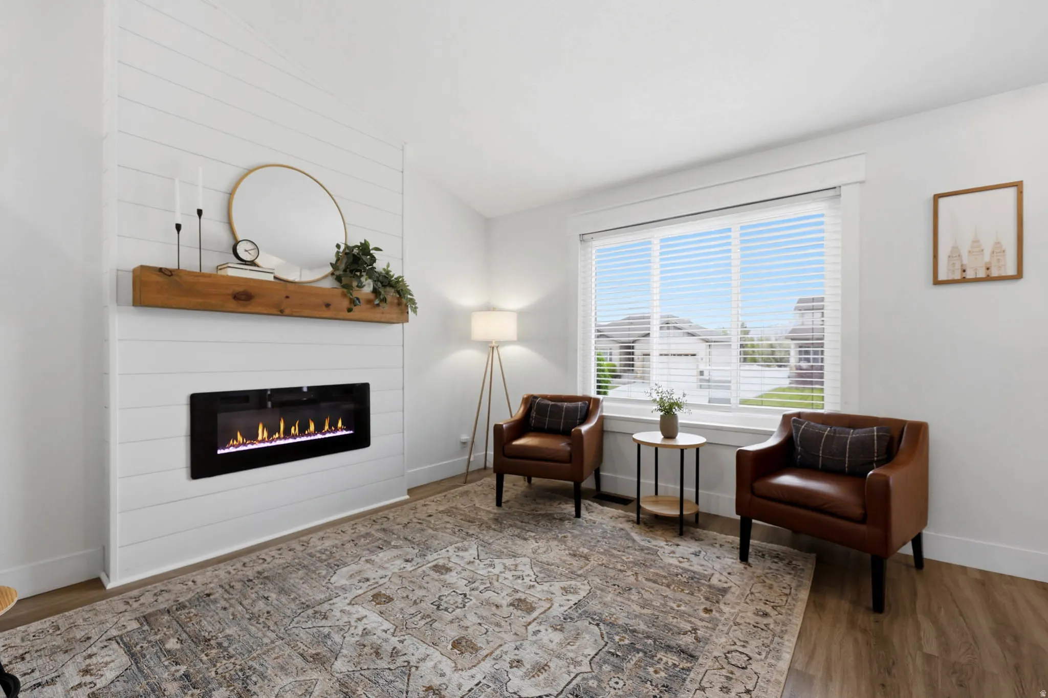 Living area featuring lofted ceiling, wood finished floors, and a large fireplace