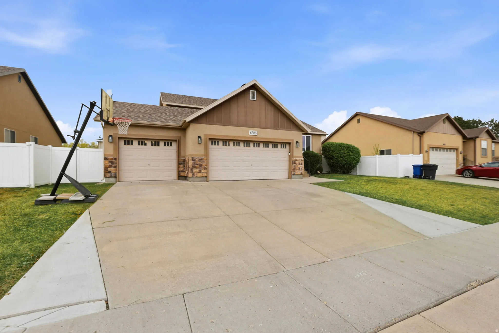 View of front facade with an attached garage, a shingled roof, concrete driveway, and stone siding