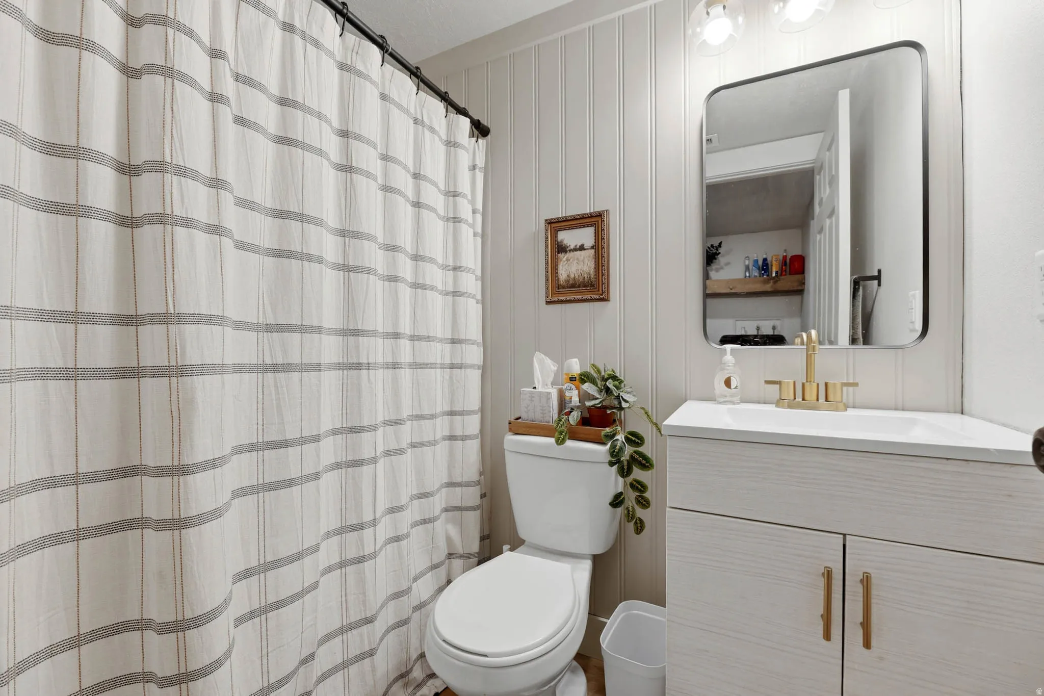 Bathroom with vanity, a shower with curtain, and wooden walls