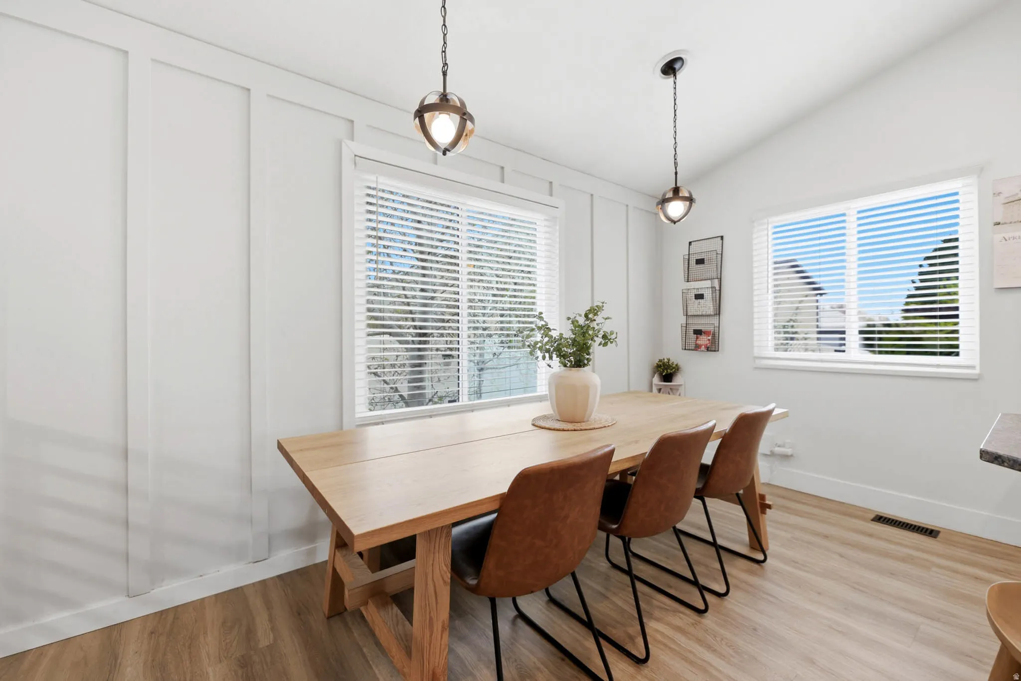 Dining area featuring light wood-type flooring and vaulted ceiling