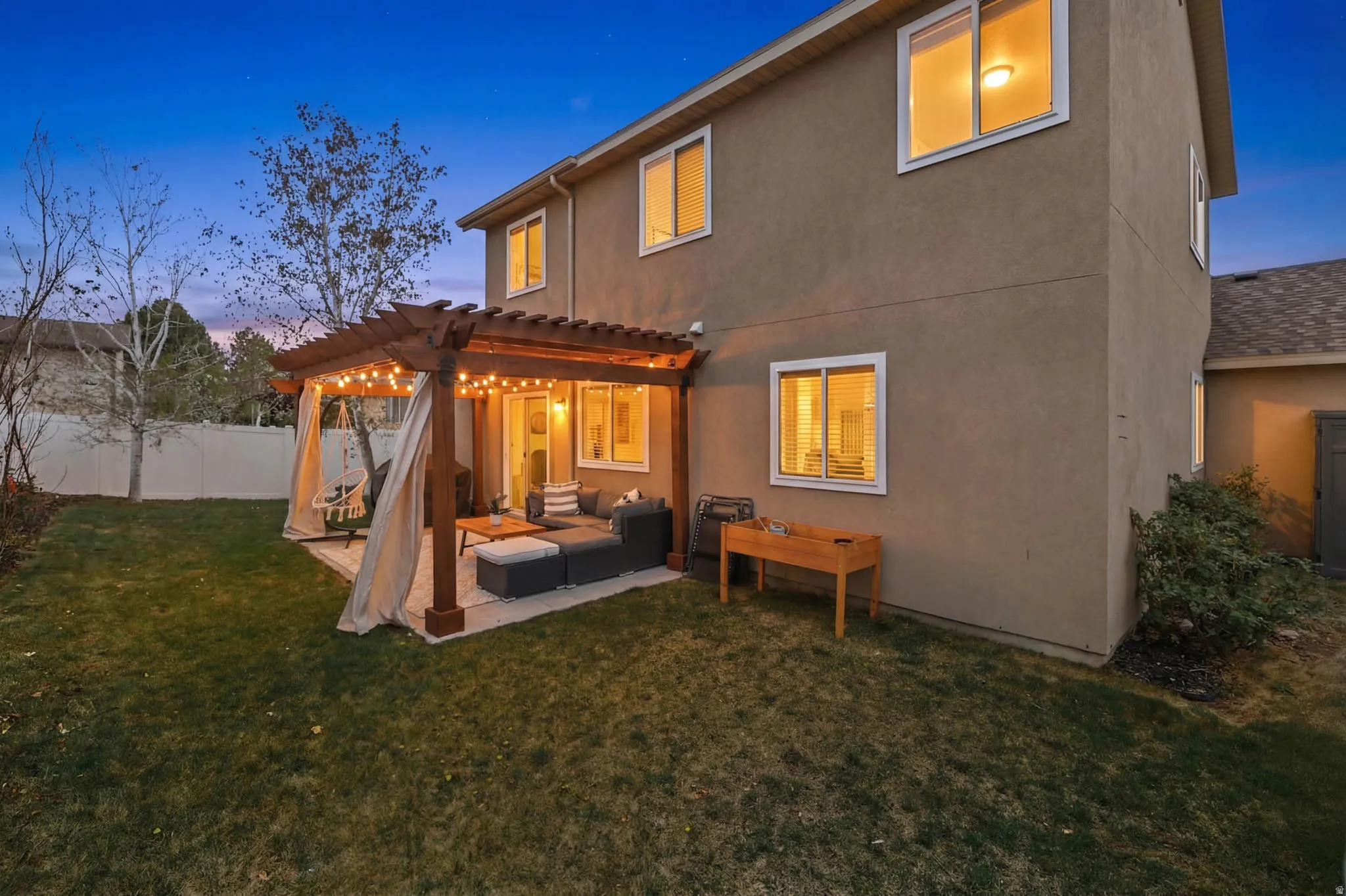 Back of house featuring a pergola, an outdoor lounge area, stucco siding, and a patio area