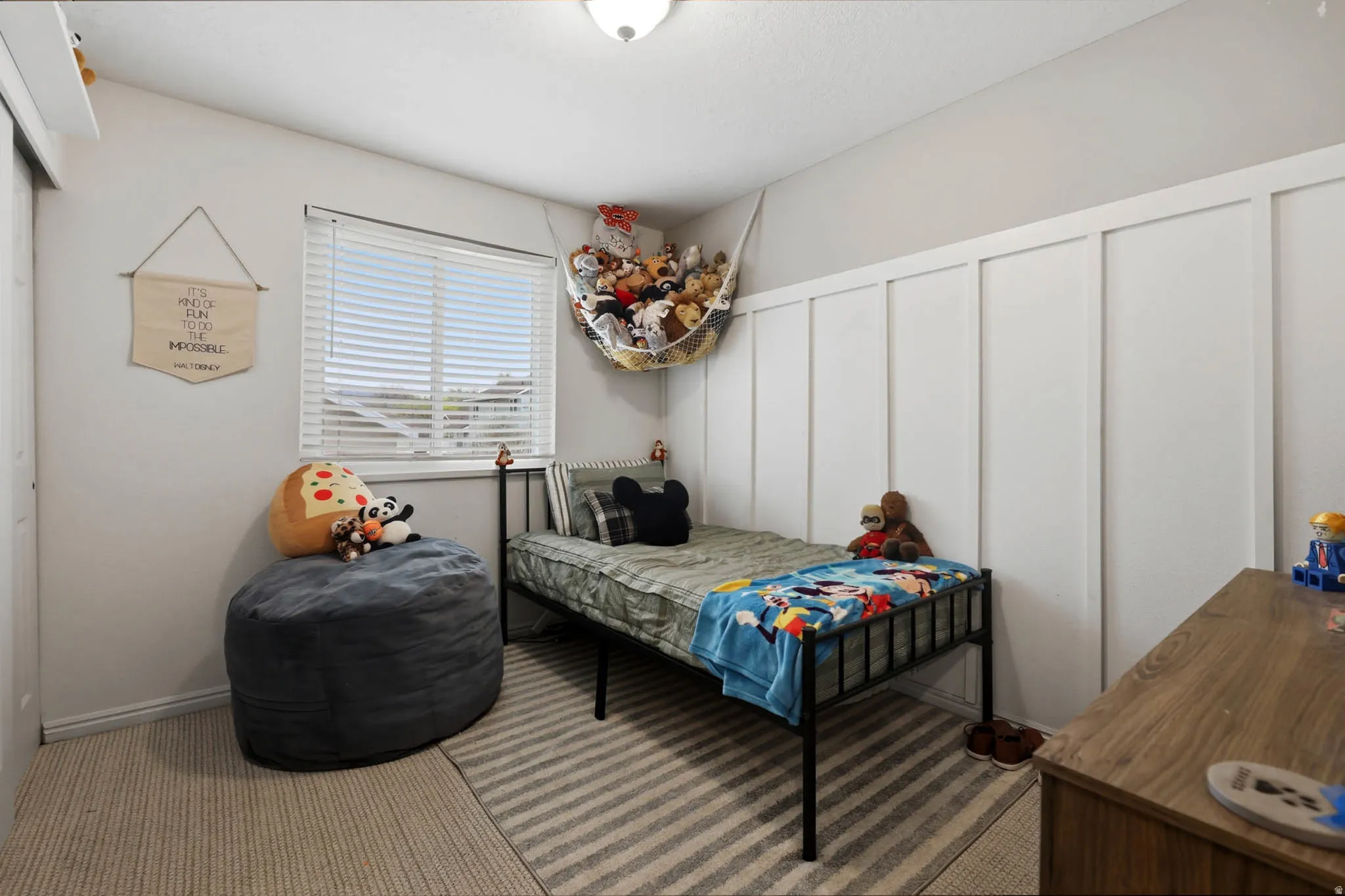 Bedroom featuring a decorative wall, carpet, and a closet