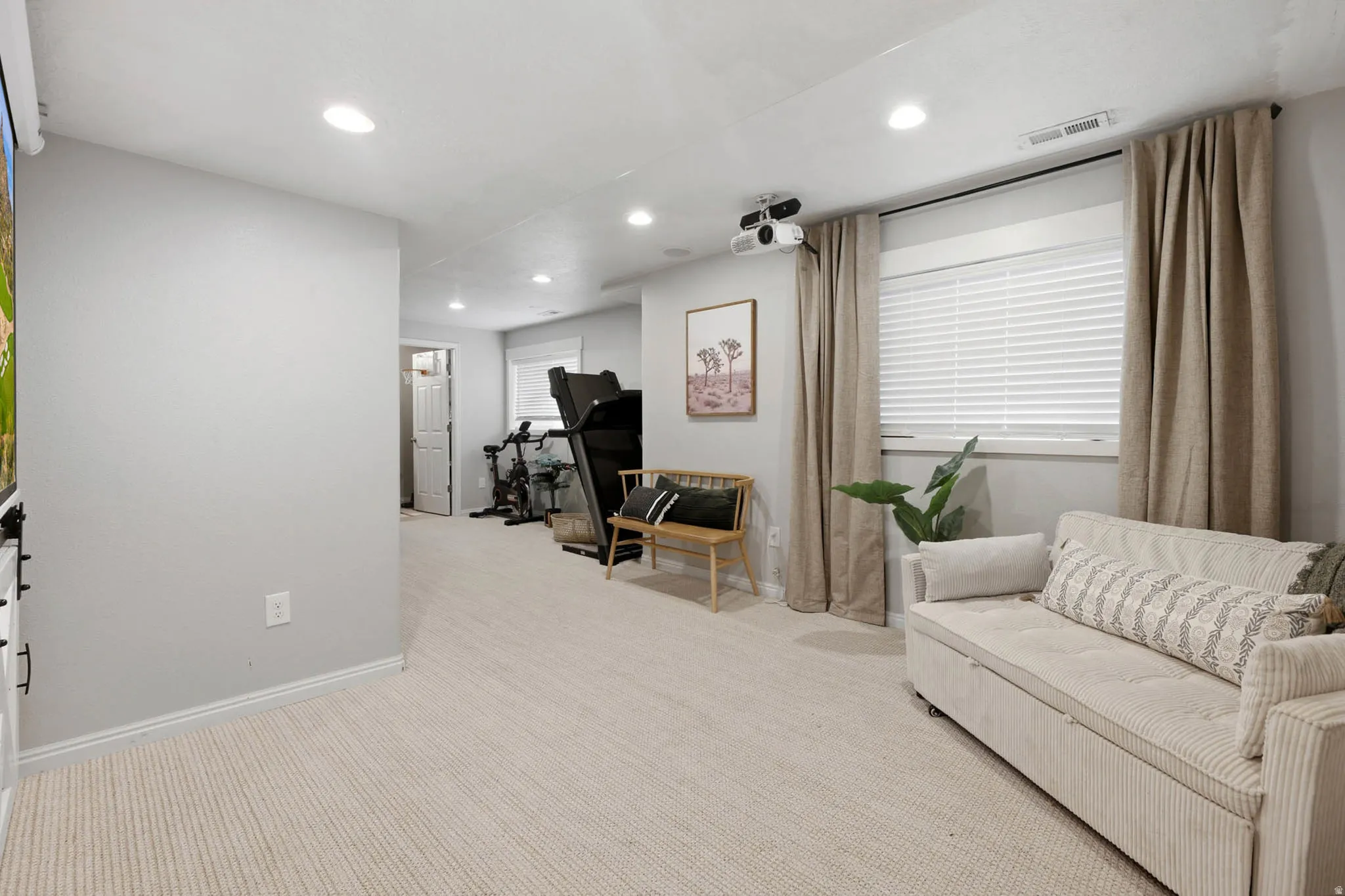 Living area with light colored carpet and recessed lighting