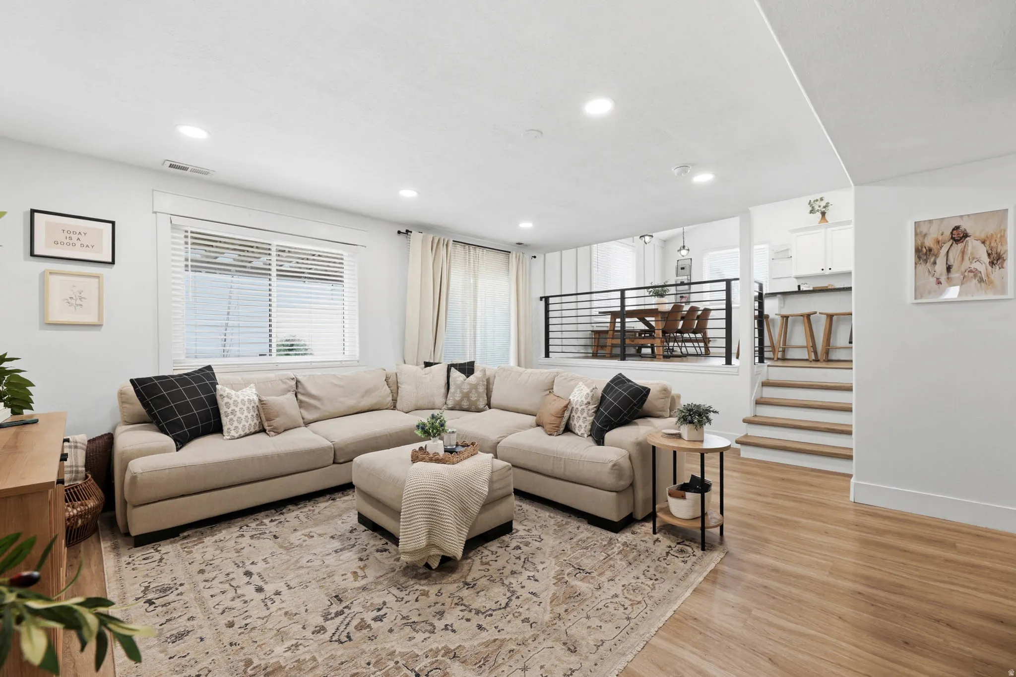 Living room with light wood-type flooring and recessed lighting