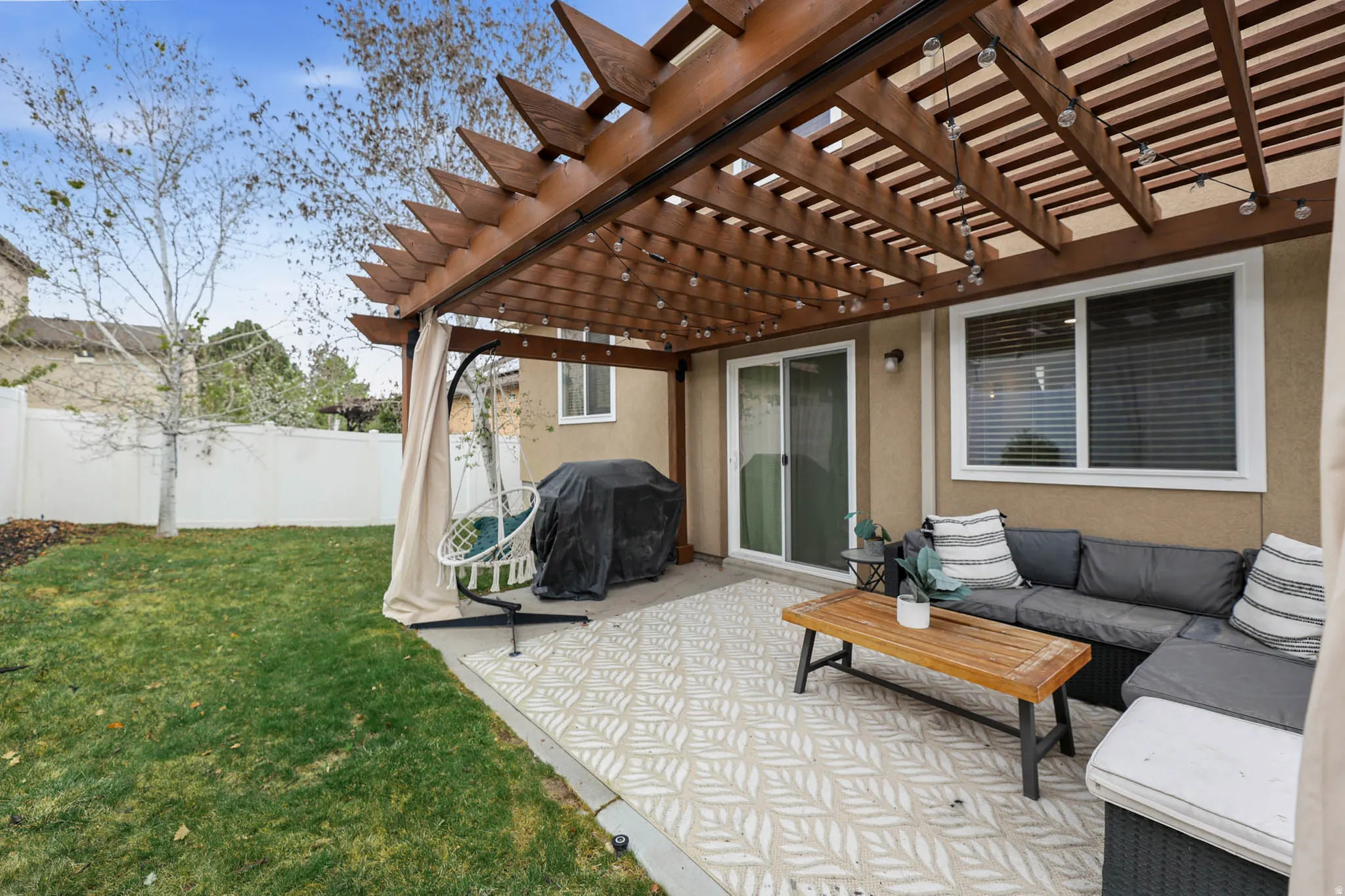 Fenced backyard with a pergola, a grill, a patio area, and an outdoor living space