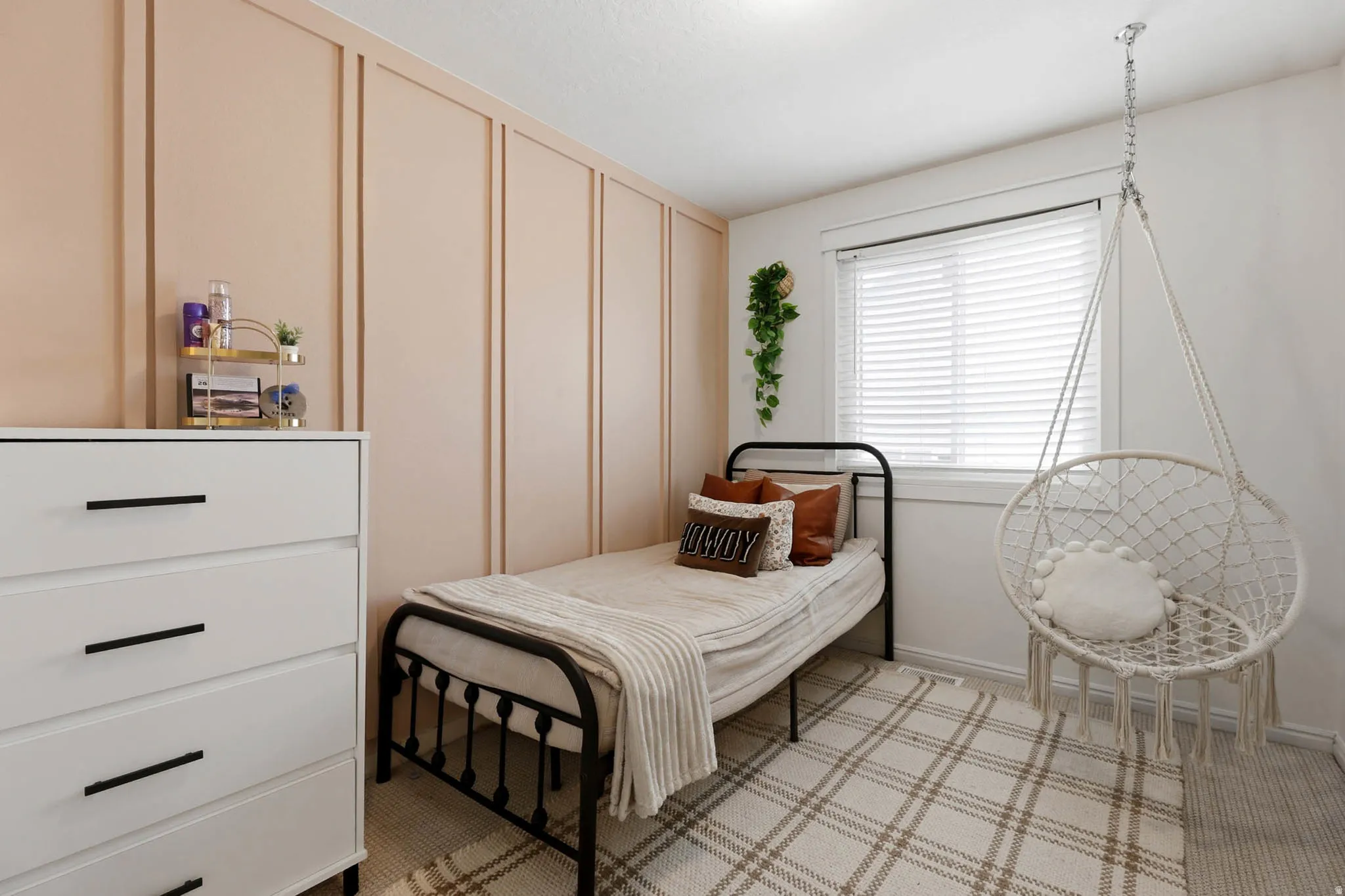 Bedroom featuring a decorative wall and light colored carpet