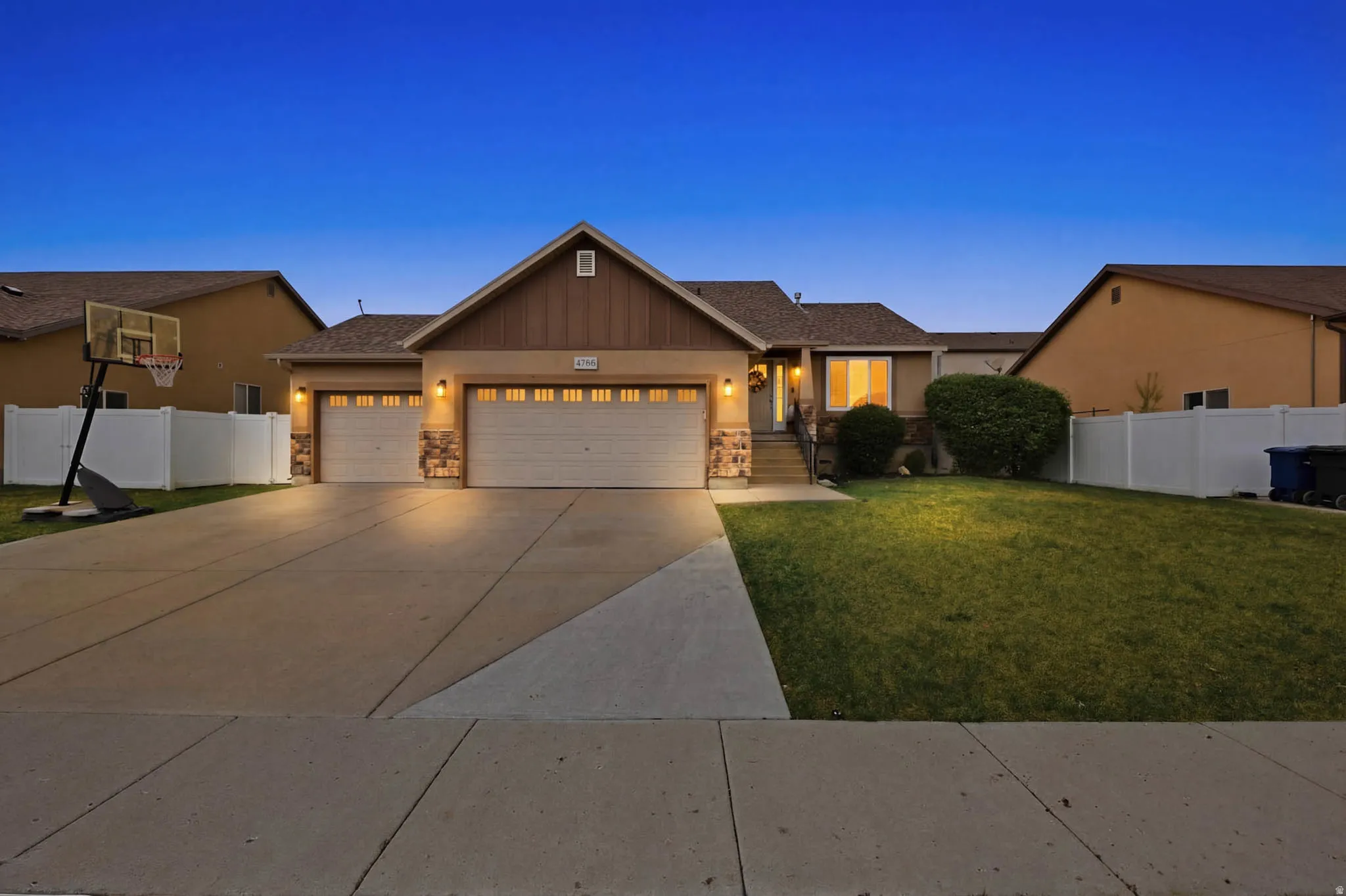Craftsman-style house featuring an attached garage, concrete driveway, stone siding, and stucco siding