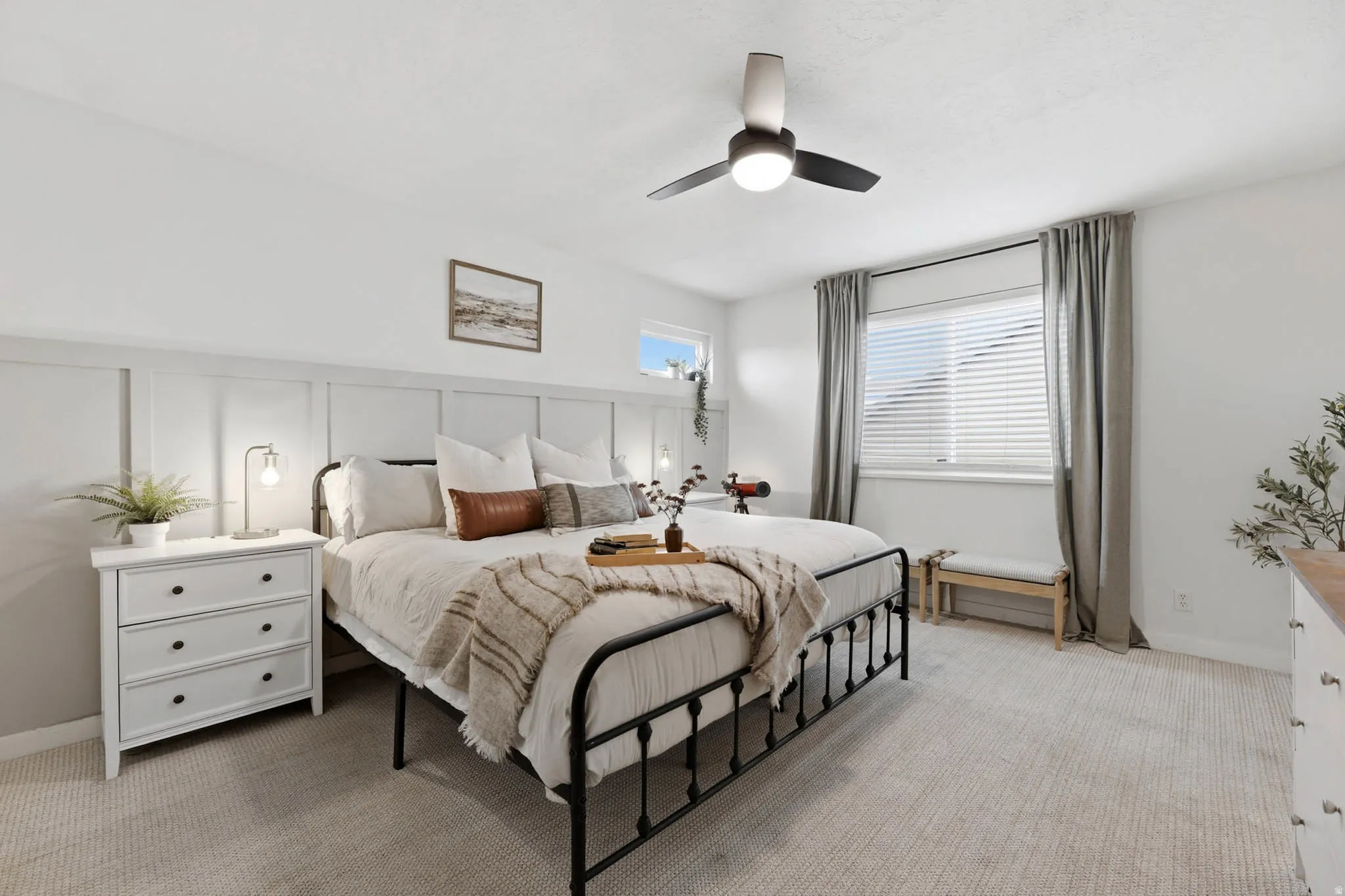 Bedroom featuring light carpet, ceiling fan, and a decorative wall
