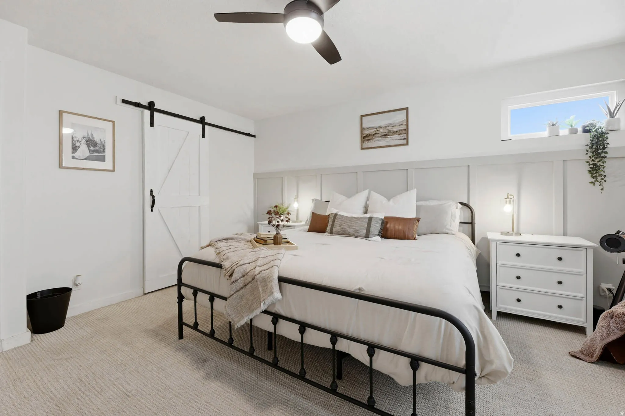 Bedroom with a barn door, carpet, and a ceiling fan