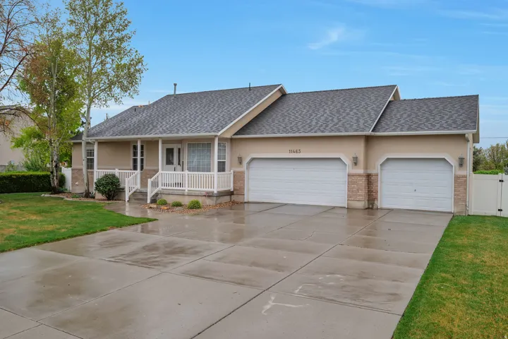Ranch-style home featuring a front yard, an attached garage, roof with shingles, covered porch, and brick siding