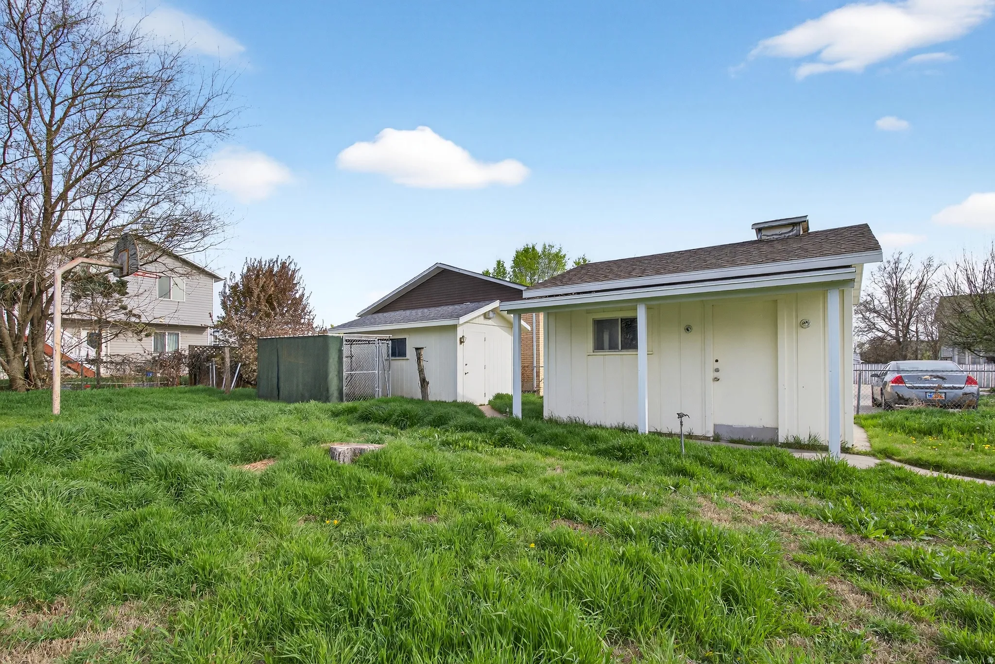 Rear view of property with a storage shed, roof with shingles, and board and batten siding