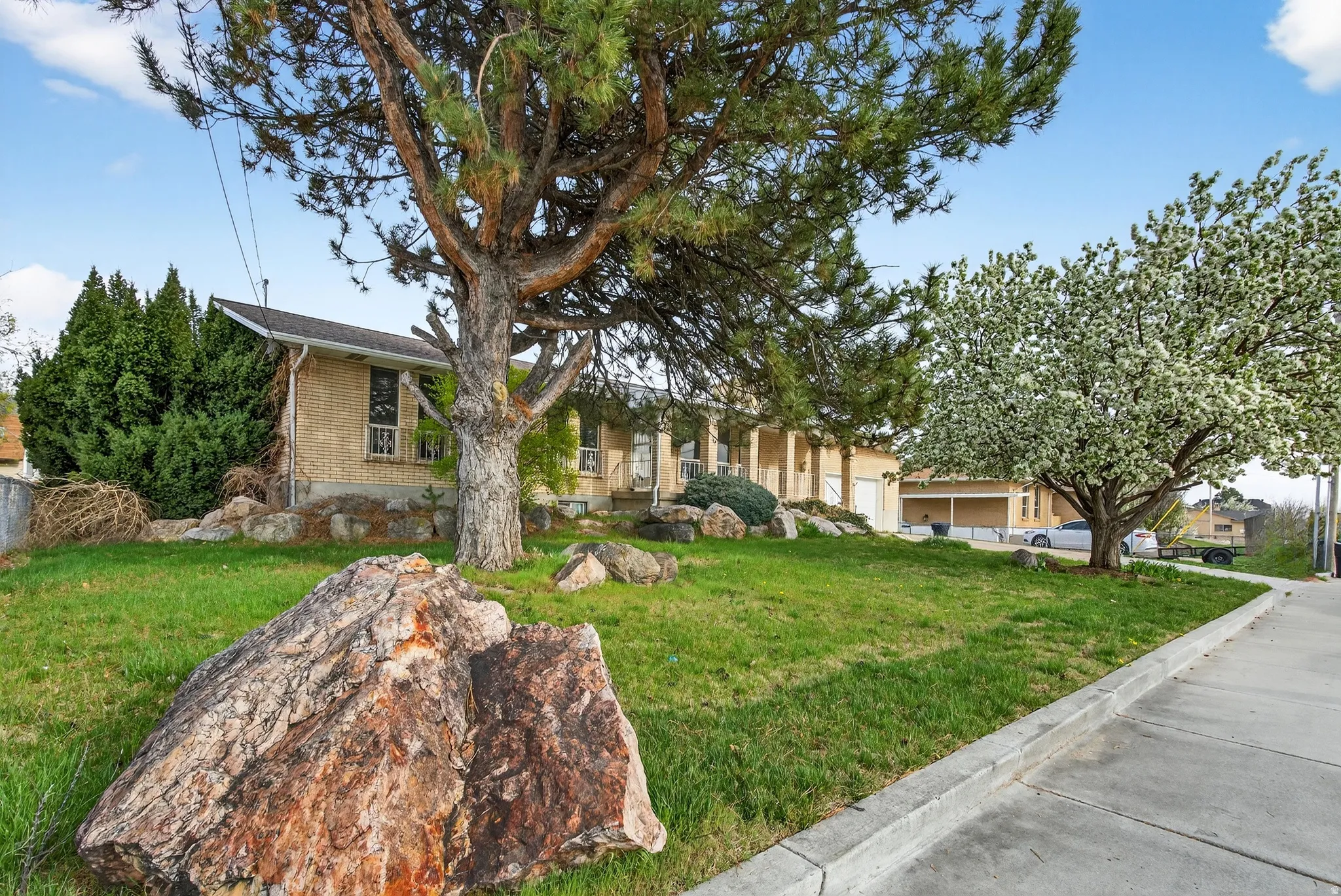 Obstructed view of property featuring a front yard and brick siding