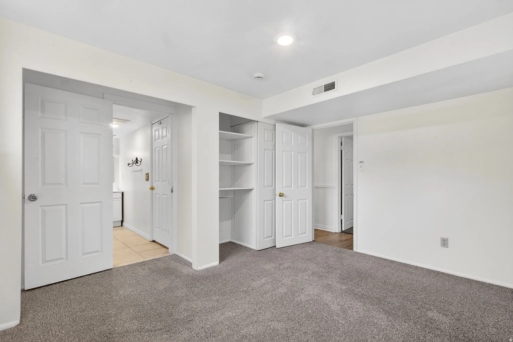 Unfurnished bedroom featuring light carpet and a closet
