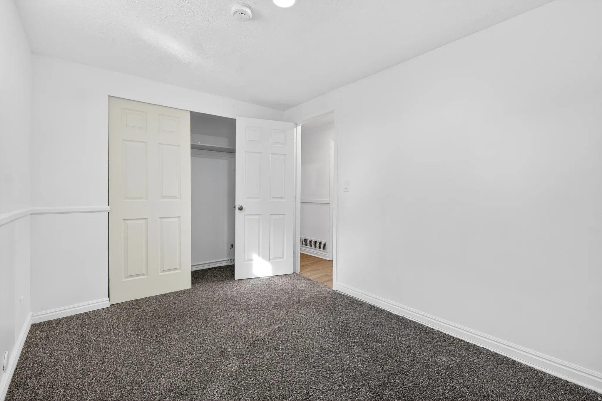 Unfurnished bedroom with light colored carpet and a closet