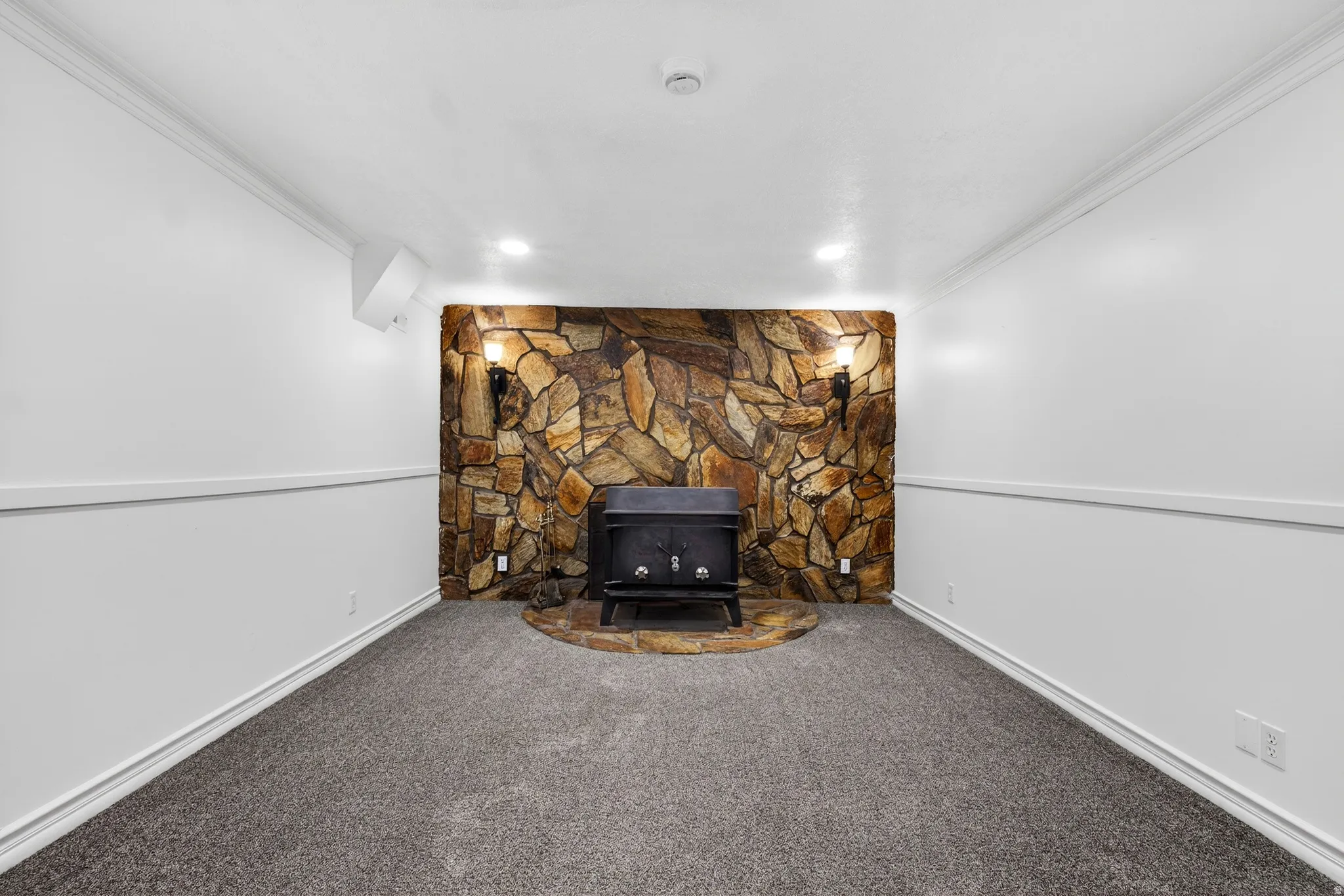 Detailed view of crown molding, carpet, and a wood stove