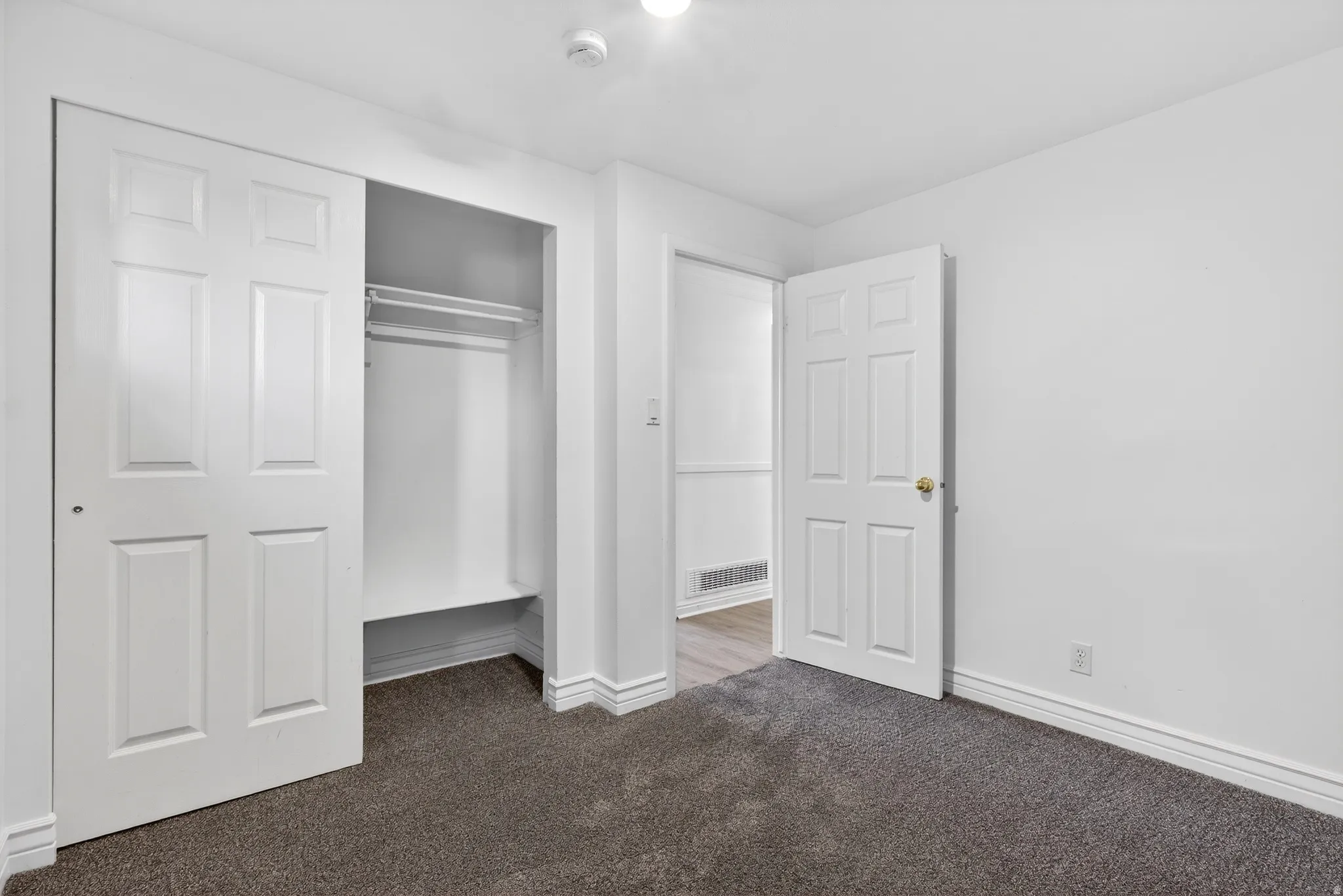 Unfurnished bedroom with dark carpet and a closet