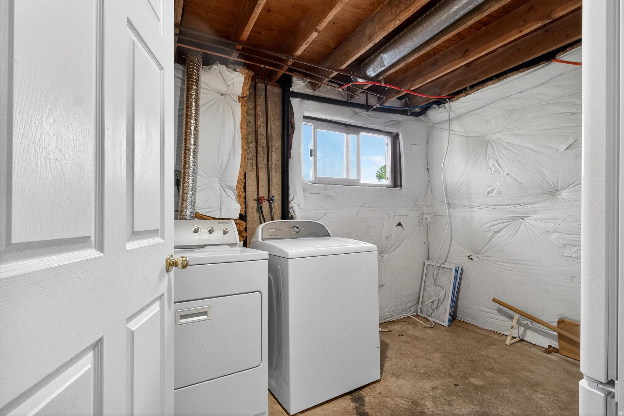 Laundry area featuring concrete flooring and independent washer and dryer