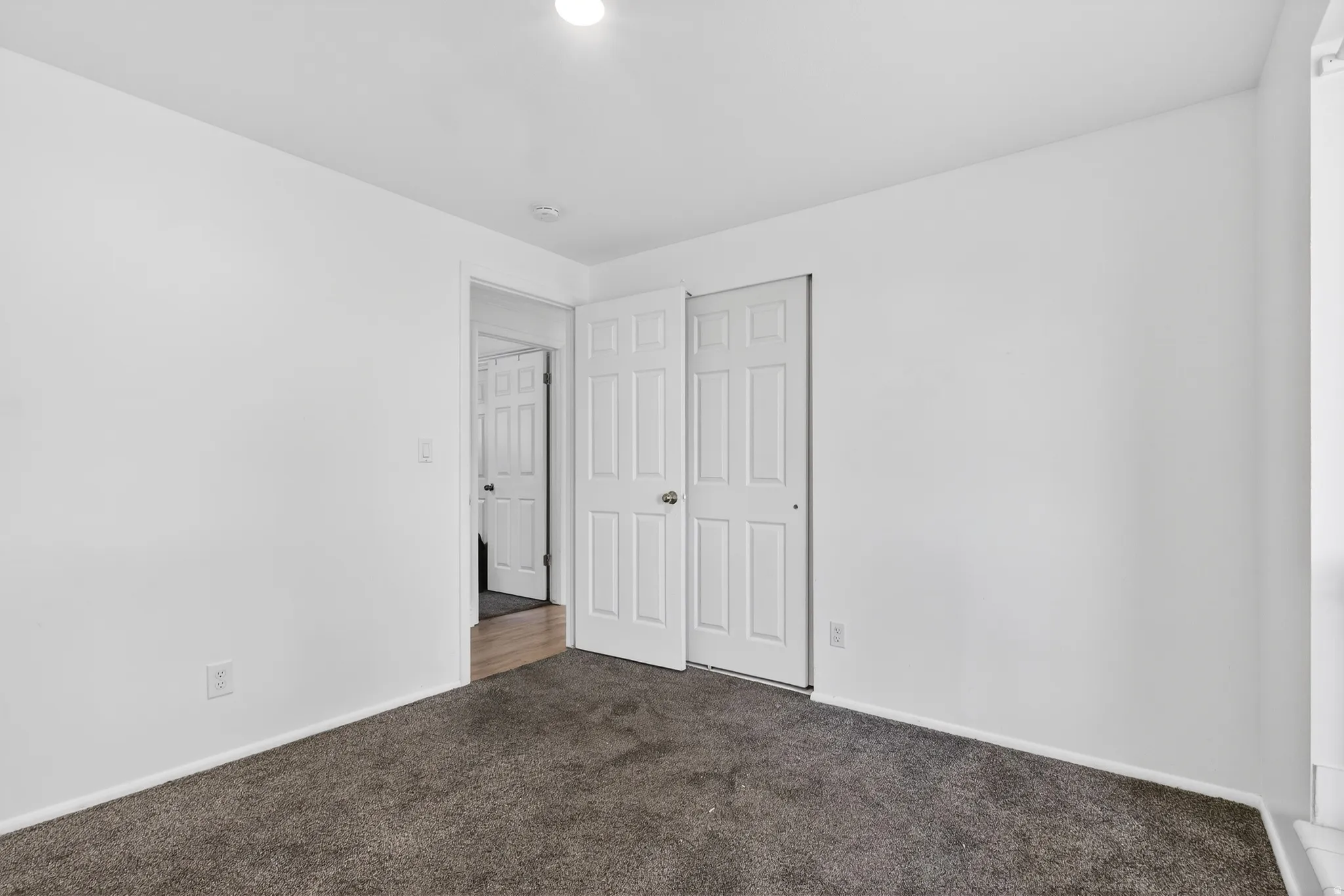 Unfurnished bedroom featuring dark colored carpet and a closet