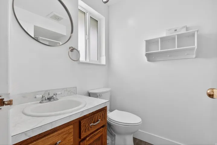 Half bathroom with vanity and wood finished floors