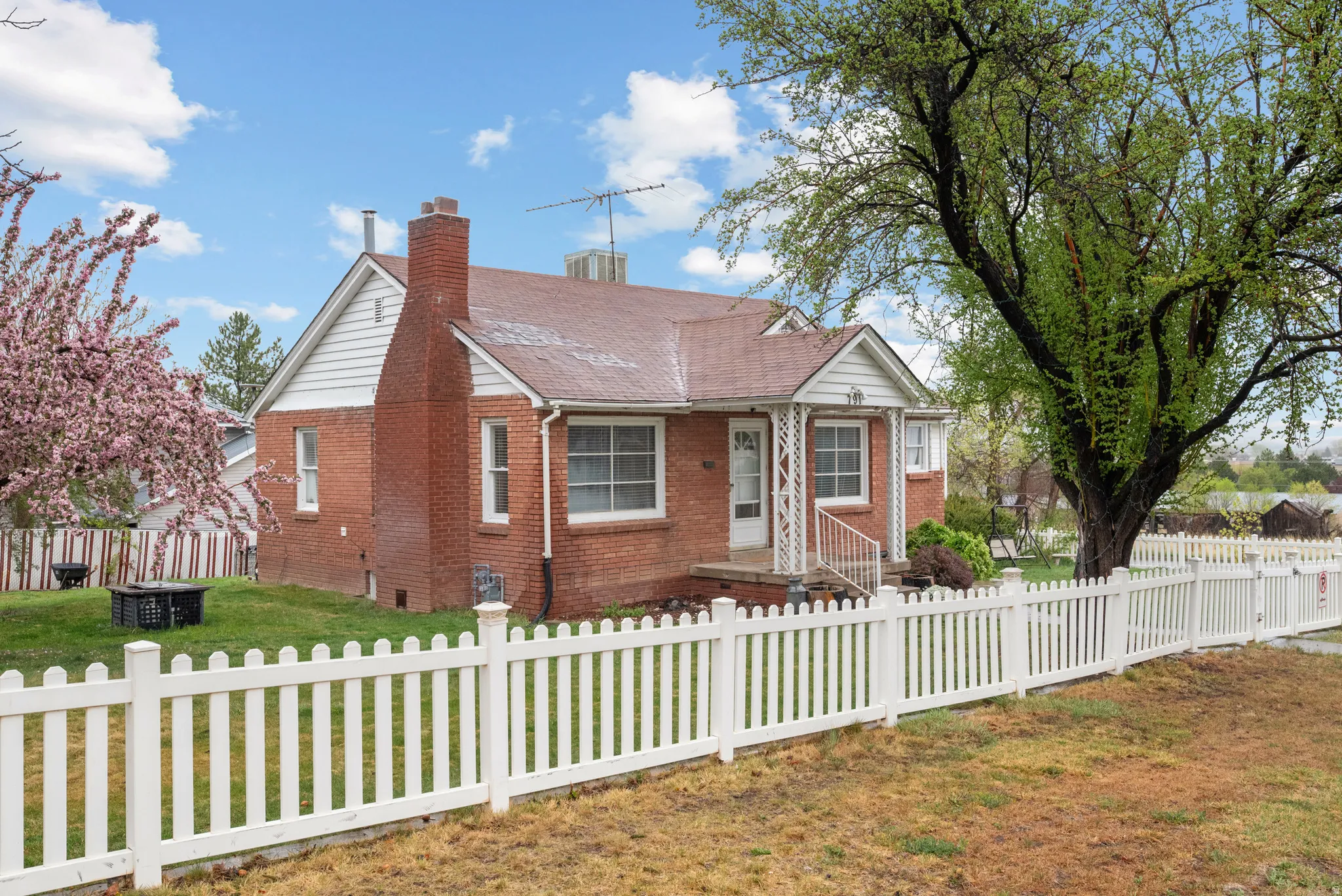 Bungalow-style home featuring brick siding and a chimney