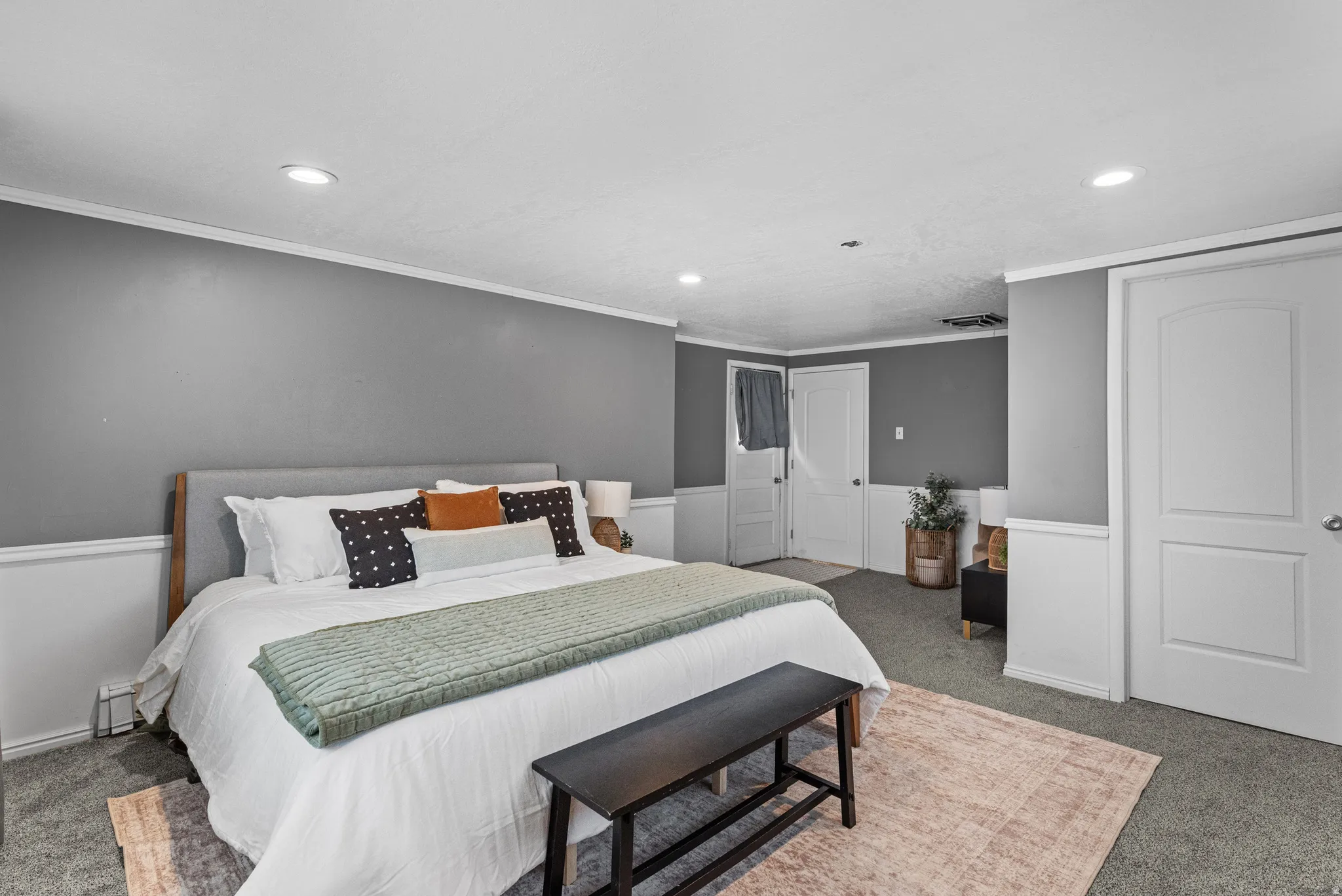 Carpeted bedroom with recessed lighting, ornamental molding, and wainscoting