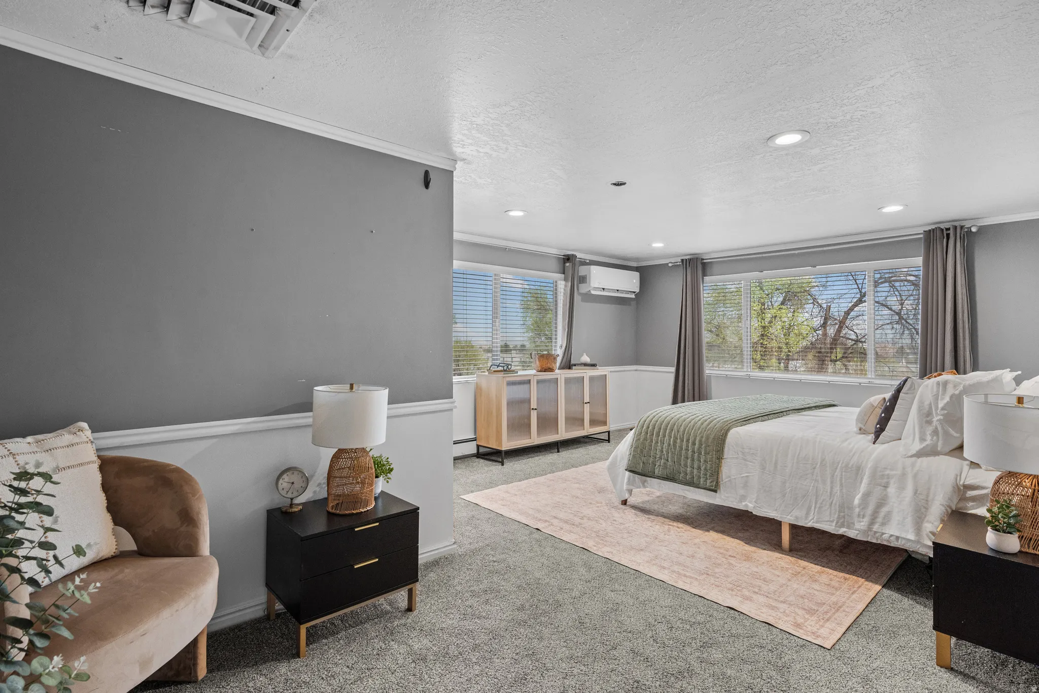 Carpeted bedroom with a textured ceiling, multiple windows, recessed lighting, and ornamental molding