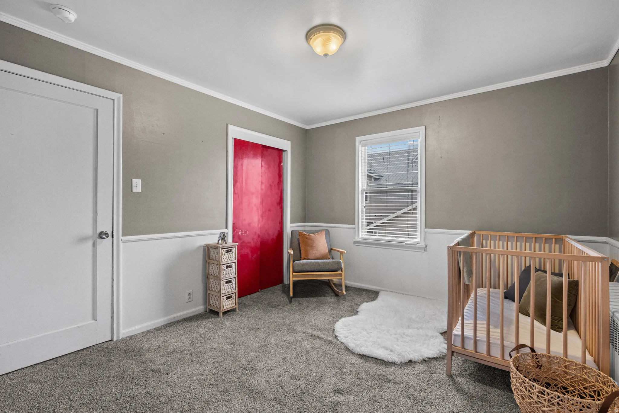 Bedroom with a crib, carpet, and crown molding