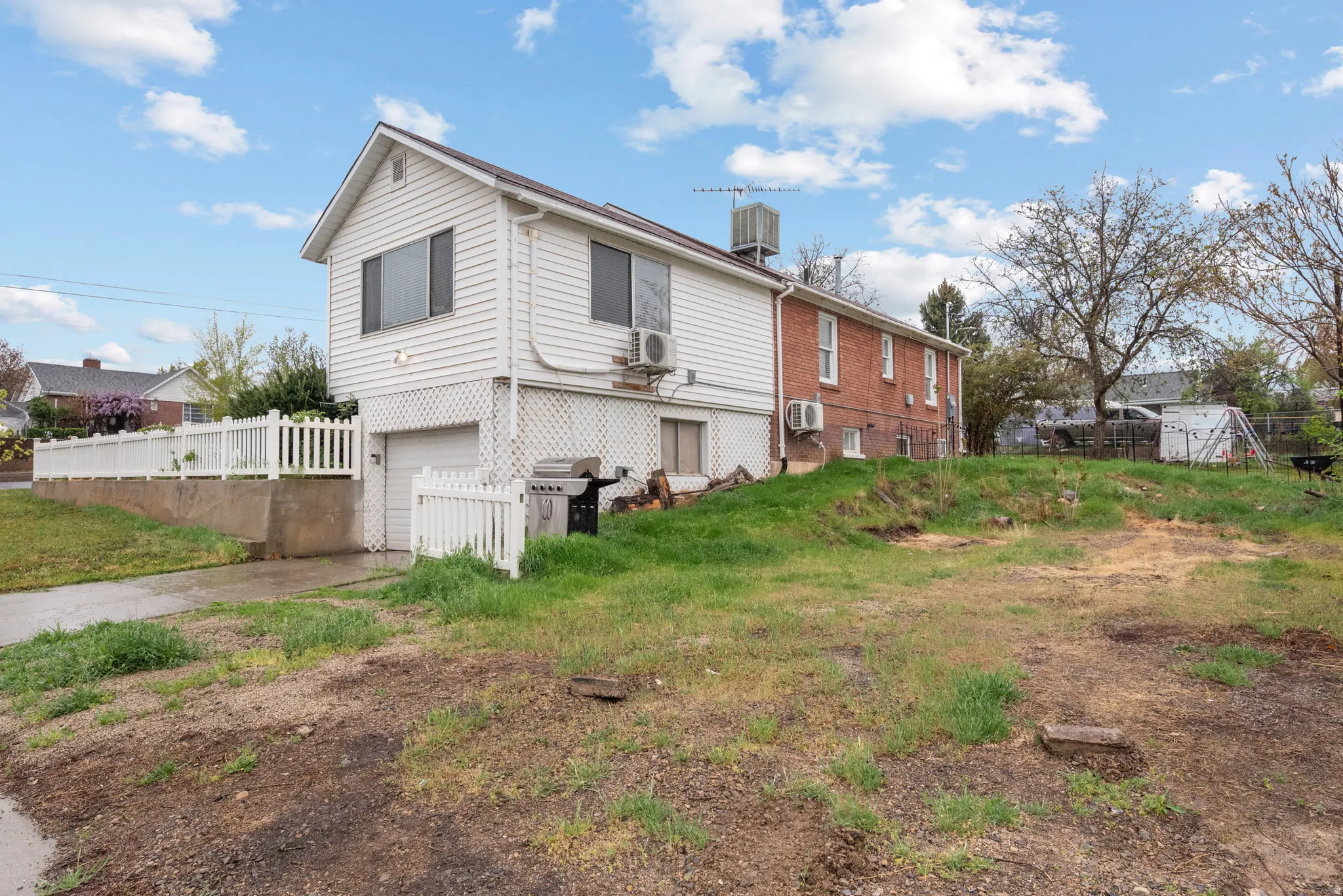 View of home's exterior with an attached garage, brick siding, and driveway