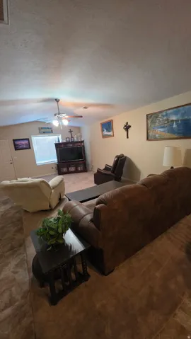 Living area featuring a textured ceiling and ceiling fan