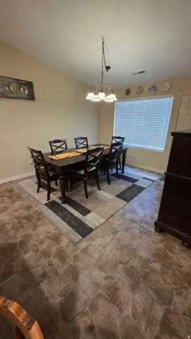 Dining space featuring stone finish floors and a chandelier