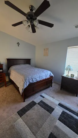 Bedroom featuring carpet flooring, ceiling fan, and lofted ceiling