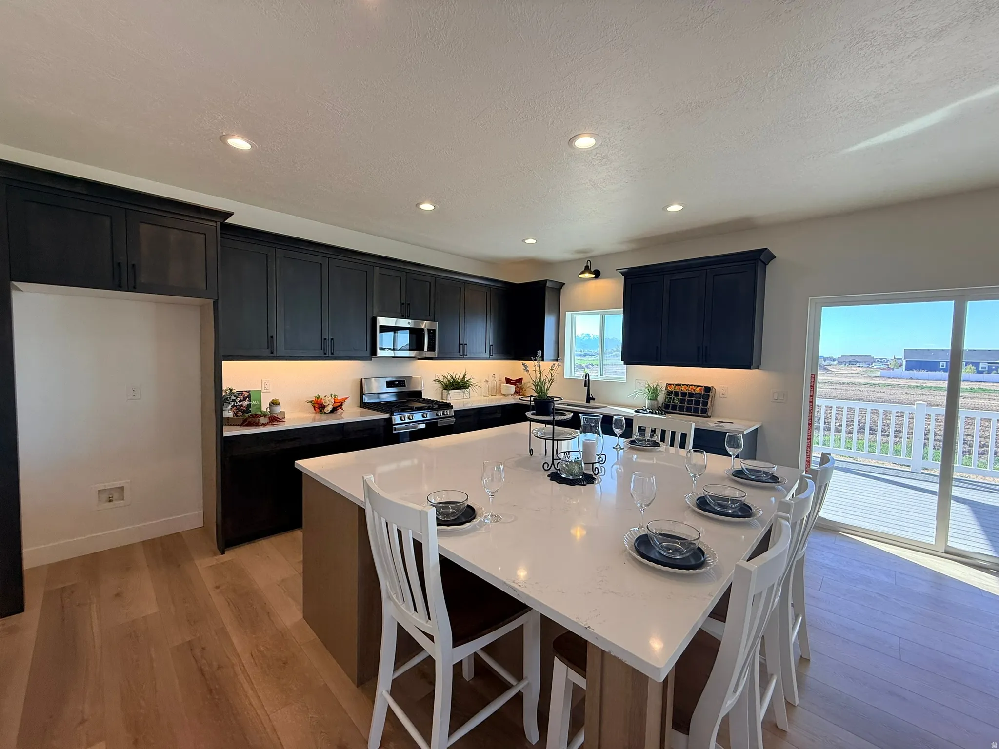 Kitchen with a breakfast bar area, a kitchen island, stainless steel appliances, light wood-style floors, and recessed lighting