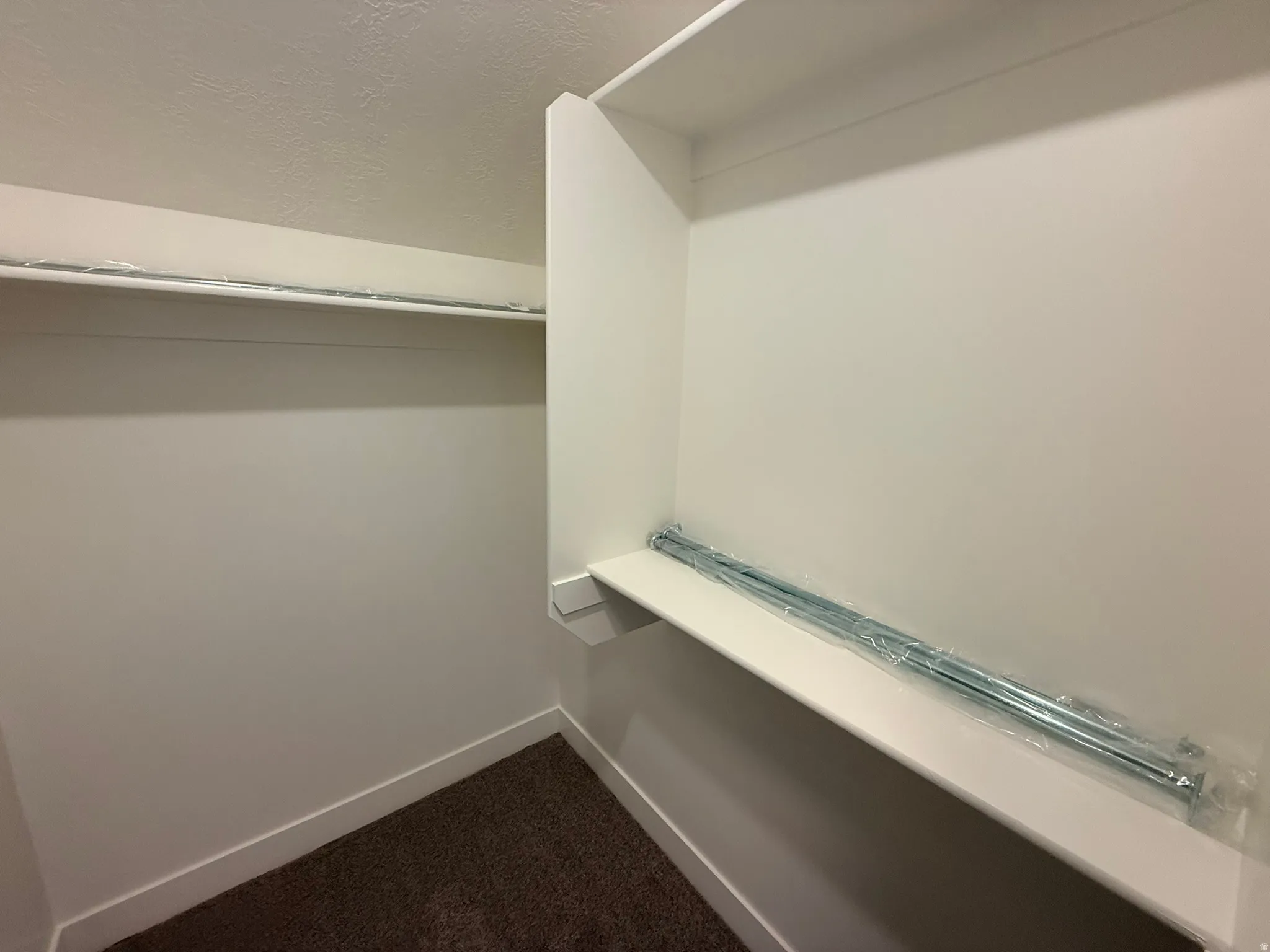 Walk in closet featuring dark carpet