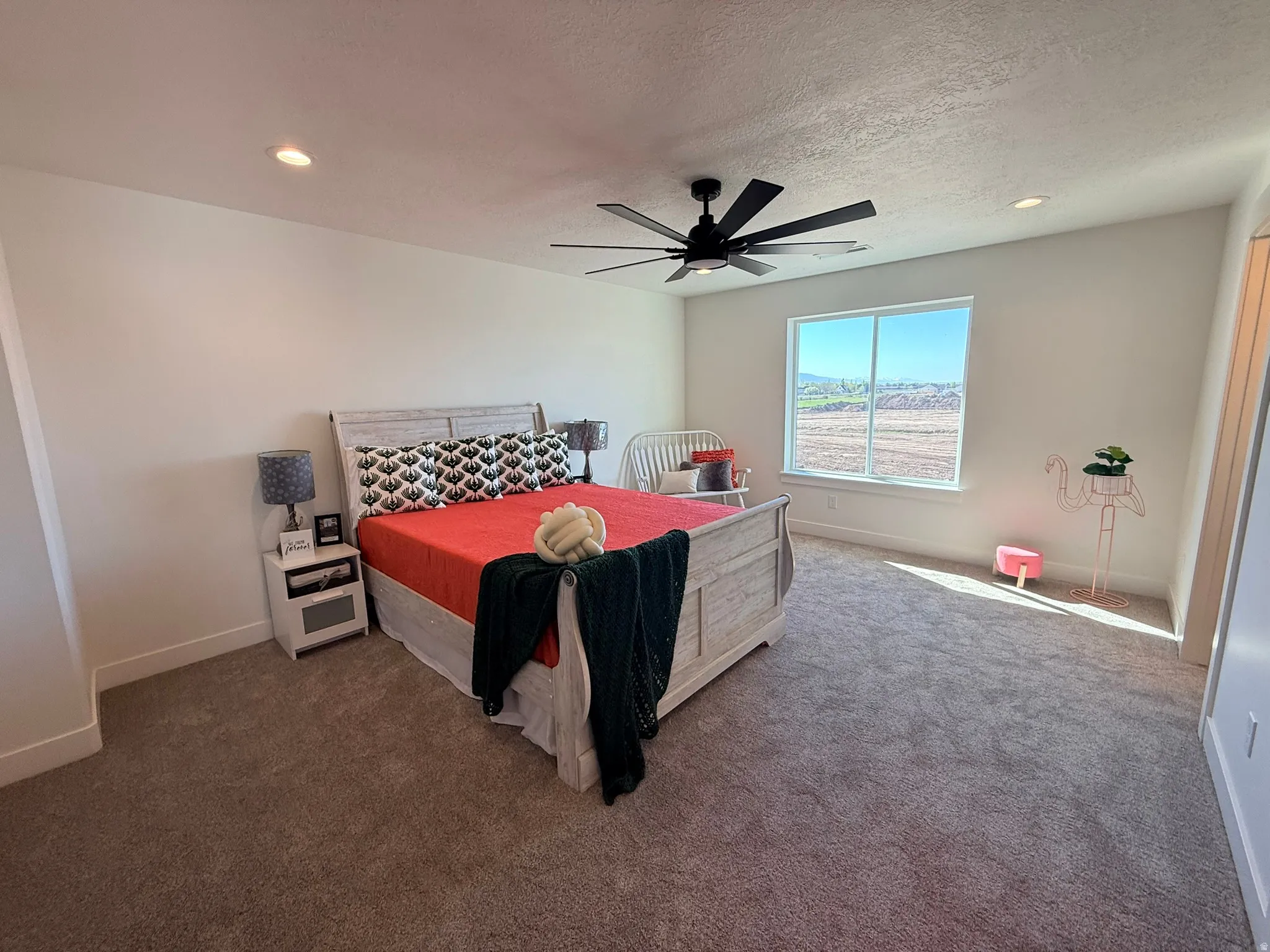 Carpeted bedroom featuring recessed lighting, a ceiling fan, and a textured ceiling