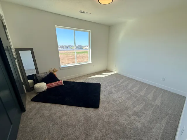Bedroom featuring carpet and baseboards