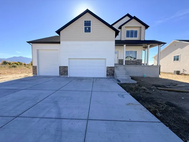 Craftsman inspired home with stone siding, a porch, driveway, a mountain view, and an attached garage