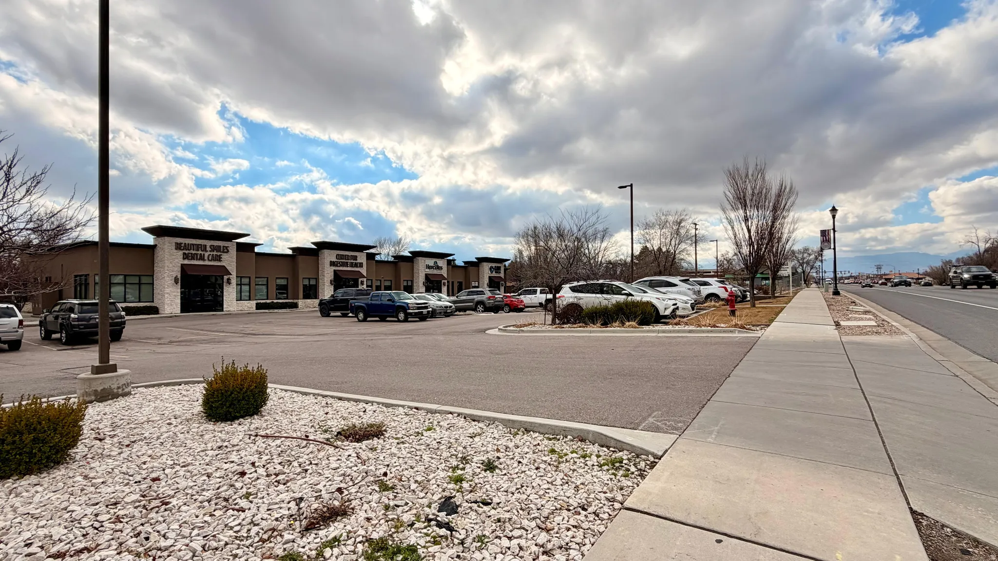 View of asphalt street with street lights, sidewalks, and curbs